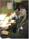 Photo of a user testing a program while a usability expert takes notes